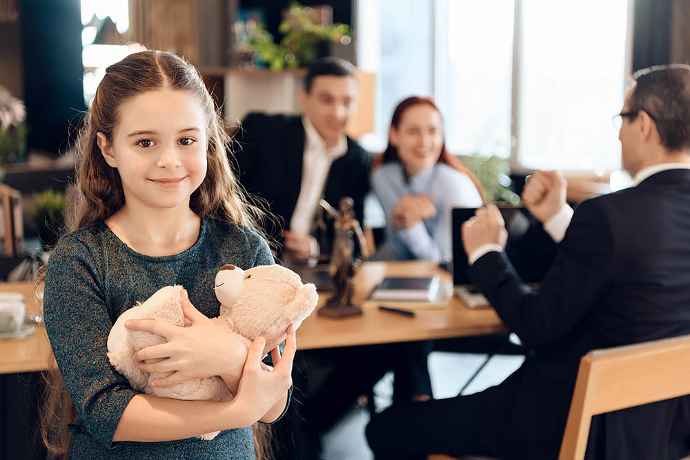 Happy little girl is hugging teddy bear at office of family lawyer. Child Support Attorney Paul J. Ryan at Ryan Family Law